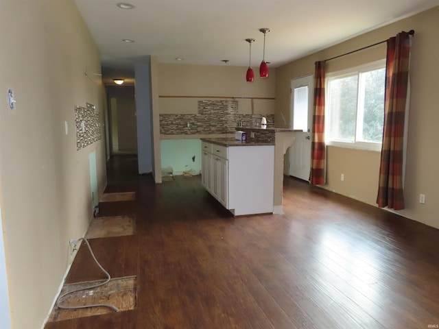 3910 Stringtown Rd, Evansville, IN 47711 - kitchen featuring white cabinets, backsplash, dark wood finished floors, a kitchen island, and decorative light fixtures
