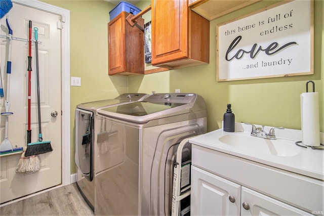 55705 Sichuan Dr, Osceola, IN 46561 - laundry area featuring cabinet space, independent washer and dryer, and light wood-type flooring