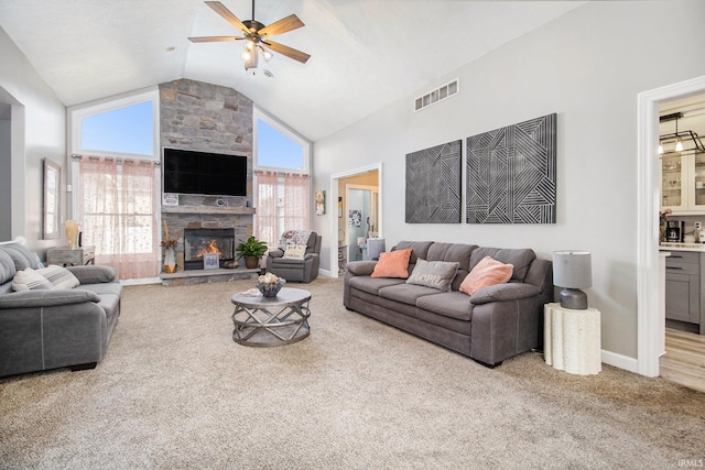55705 Sichuan Dr, Osceola, IN 46561 - living room with high vaulted ceiling, a ceiling fan, carpet, a stone fireplace, and baseboards