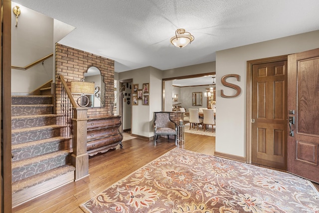 1365 W 15th St, Jasper, IN 47546 - foyer with stairs, light wood-style floors, a textured ceiling, and baseboards