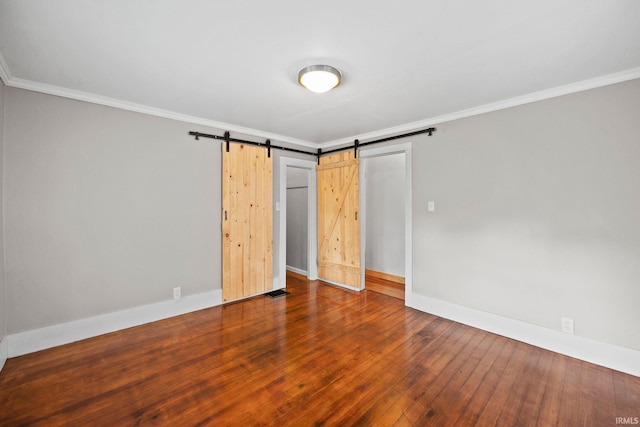 204 N W St, Attica, IN 47918 - unfurnished bedroom featuring a barn door, crown molding, baseboards, and wood finished floors