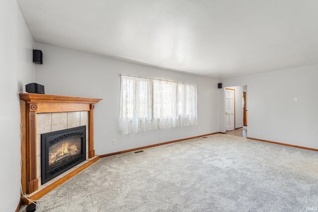 4294 E Defreese Rd, Syracuse, IN 46567 - unfurnished living room with a tiled fireplace, carpet floors, and baseboards