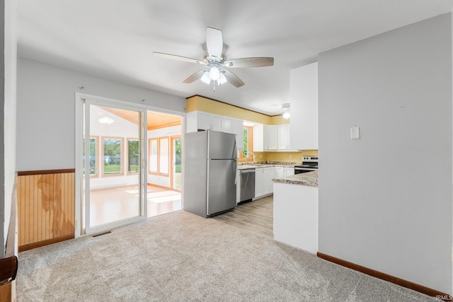 4294 E Defreese Rd, Syracuse, IN 46567 - kitchen with appliances with stainless steel finishes, white cabinets, a ceiling fan, light carpet, and light countertops