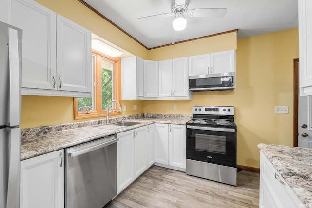 4294 E Defreese Rd, Syracuse, IN 46567 - kitchen with stainless steel appliances, a sink, light wood-type flooring, ceiling fan, and white cabinetry