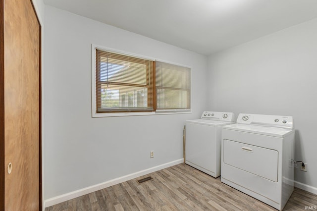 4294 E Defreese Rd, Syracuse, IN 46567 - laundry room featuring washer and clothes dryer, light wood-style flooring, and baseboards