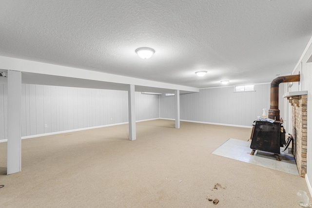4294 E Defreese Rd, Syracuse, IN 46567 - finished below grade area with a wood stove, carpet flooring, and a textured ceiling