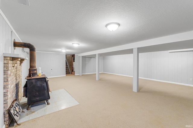 4294 E Defreese Rd, Syracuse, IN 46567 - finished basement with carpet floors, stairs, a wood stove, a textured ceiling, and baseboards