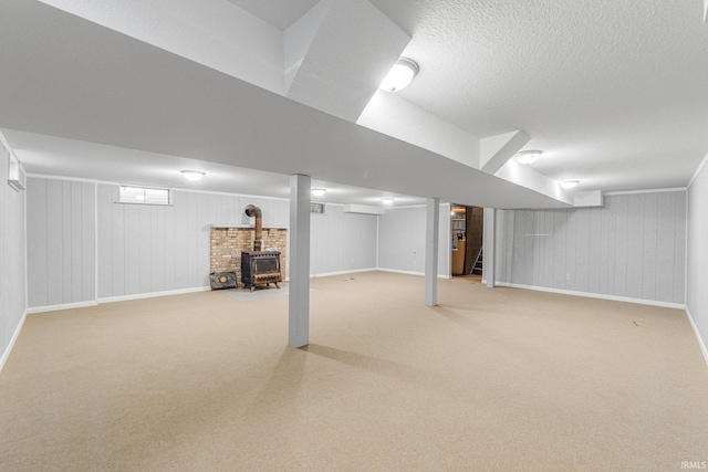 4294 E Defreese Rd, Syracuse, IN 46567 - finished basement with a wood stove, carpet flooring, baseboards, and a textured ceiling
