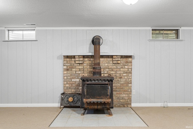 4294 E Defreese Rd, Syracuse, IN 46567 - basement view of a wood stove, a textured ceiling, wood walls, and carpet
