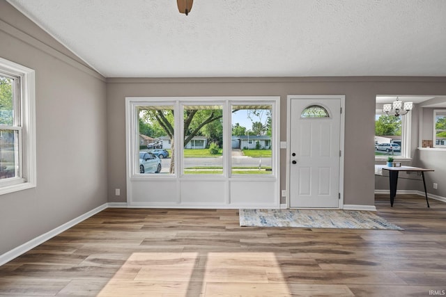 1008 Beck Ln, Lafayette, IN 47909 - foyer with a chandelier, plenty of natural light, wood finished floors, and a textured ceiling