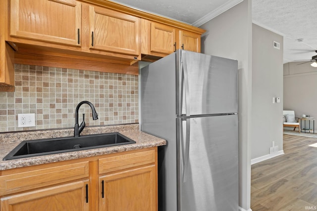 1008 Beck Ln, Lafayette, IN 47909 - kitchen featuring freestanding refrigerator, a sink, tasteful backsplash, wood finished floors, and ornamental molding
