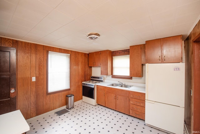 2331 N 24th St, Lafayette, IN 47904 - kitchen with white appliances, healthy amount of natural light, light countertops, brown cabinetry, and wooden walls