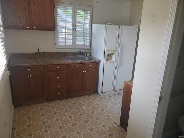 406 W Rogers St, Osceola, IN 46561 - kitchen featuring a sink, white refrigerator with ice dispenser, brown cabinets, and light floors