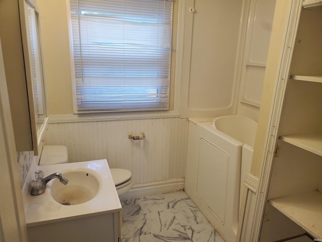 406 W Rogers St, Osceola, IN 46561 - bathroom with marble finish floors, toilet, vanity, wainscoting, and a bath