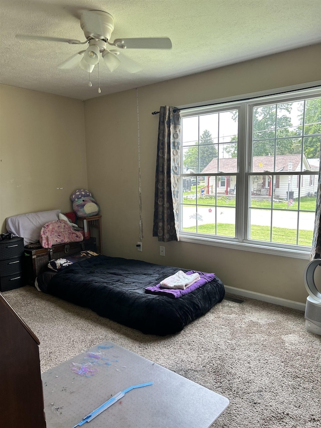 1406 Hillcrest Rd, Bedford, IN 47421 - bedroom featuring multiple windows, ceiling fan, carpet, a textured ceiling, and baseboards