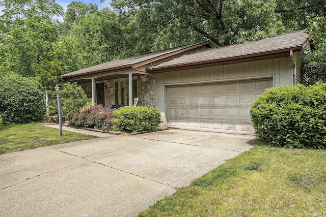 17411 Woodhurst Rd, Granger, IN 46530 - ranch-style house with a garage, concrete driveway, stone siding, a front lawn, and roof with shingles