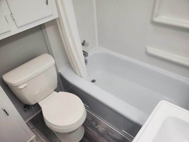 1005 E 4th St, Mishawaka, IN 46544 - full bathroom with wood finished floors, toilet, and shower / bathtub combination with curtain