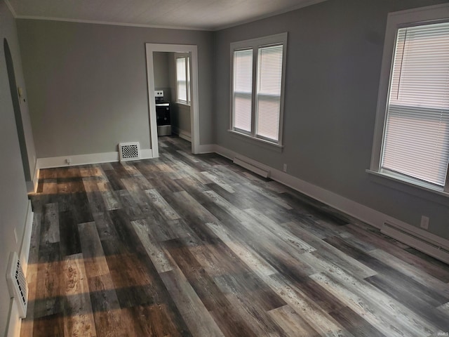 1005 E 4th St, Mishawaka, IN 46544 - spare room featuring crown molding, a baseboard heating unit, dark wood-type flooring, baseboards, and baseboard heating
