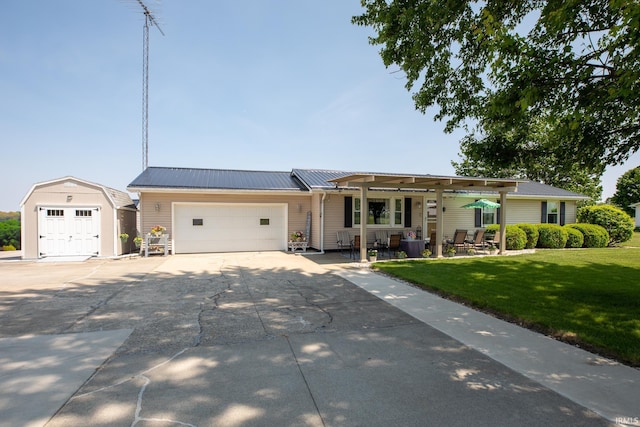 12350 Cedar Rd, Bourbon, IN 46504 - ranch-style home with a front lawn, concrete driveway, a garage, and metal roof