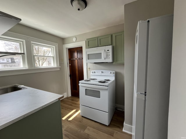 211 S Liberty St, Muncie, IN 47305 - kitchen with white appliances, green cabinetry, wood finished floors, and light countertops