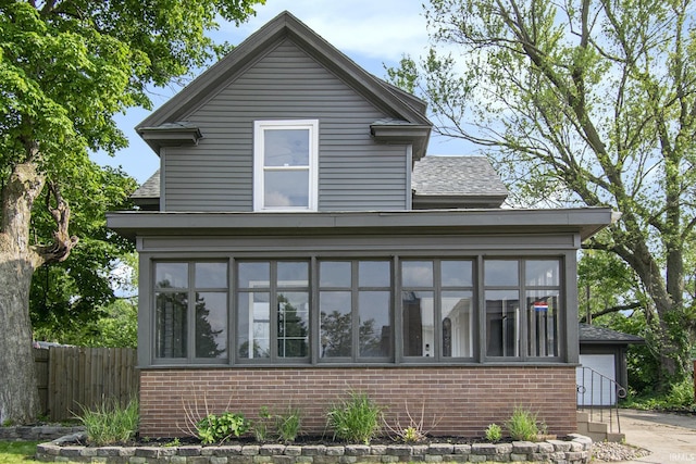 629 E 3rd St, Mishawaka, IN 46544 - view of front facade with brick siding, a sunroom, and a shingled roof