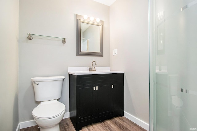 629 E 3rd St, Mishawaka, IN 46544 - bathroom with wood finished floors, toilet, baseboards, vanity, and a shower