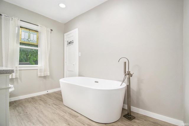 629 E 3rd St, Mishawaka, IN 46544 - full bath with wood finished floors, a freestanding tub, and baseboards