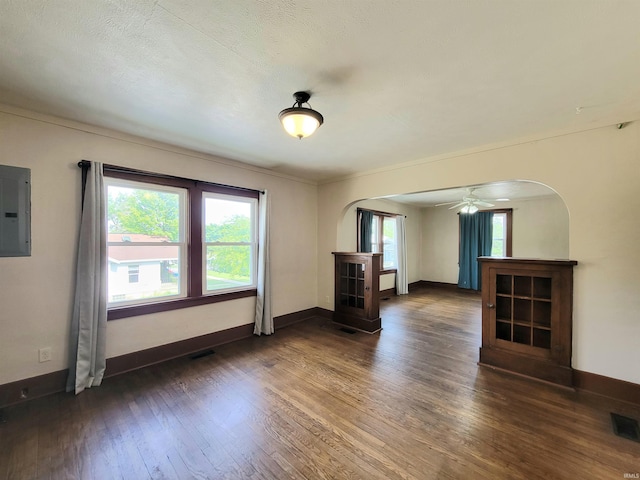 1702 Milburn Blvd, Mishawaka, IN 46544 - unfurnished living room with arched walkways, electric panel, dark wood-type flooring, and baseboards