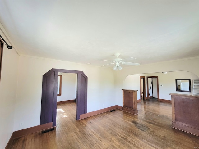 1702 Milburn Blvd, Mishawaka, IN 46544 - unfurnished living room with arched walkways, a ceiling fan, baseboards, wood finished floors, and crown molding