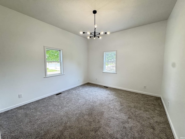 1114 N College St, Veedersburg, IN 47987 - spare room with a chandelier, plenty of natural light, dark colored carpet, and baseboards