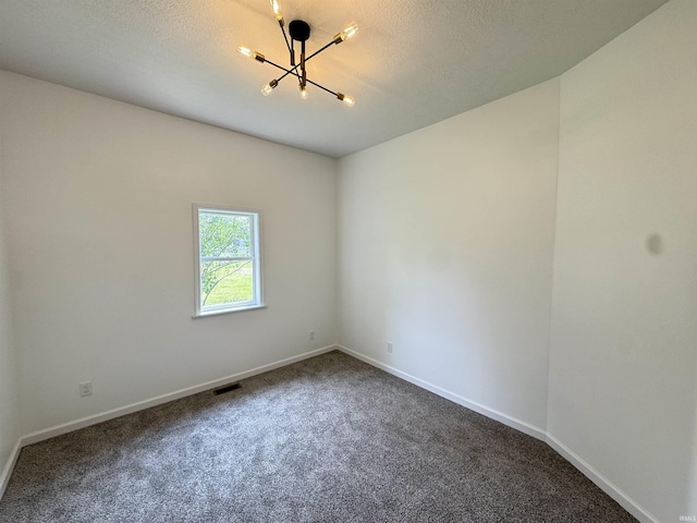 1114 N College St, Veedersburg, IN 47987 - empty room featuring a chandelier, dark carpet, and baseboards