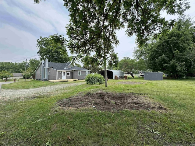 1114 N College St, Veedersburg, IN 47987 - view of green lawn with a detached carport, driveway, and a wooden deck