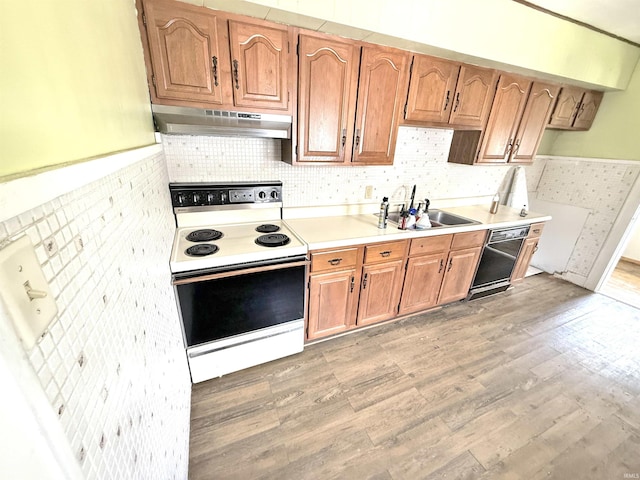 1228 Woodward Ave, New Castle, IN 47362 - kitchen featuring under cabinet range hood, electric range, a sink, light wood-style floors, and light countertops