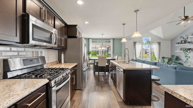 12946 Magnolia Creek Trl, Fort Wayne, IN 46814 - kitchen featuring stainless steel appliances, a sink, open floor plan, dark brown cabinetry, and dark wood-type flooring