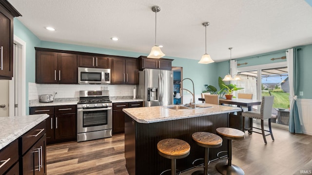 12946 Magnolia Creek Trl, Fort Wayne, IN 46814 - kitchen featuring stainless steel appliances, a sink, dark wood-style flooring, dark brown cabinets, and decorative backsplash