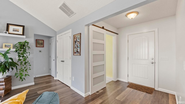 12946 Magnolia Creek Trl, Fort Wayne, IN 46814 - foyer with a barn door, wood finished floors, baseboards, and vaulted ceiling