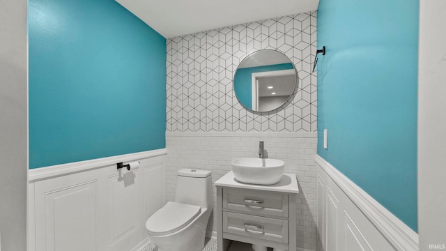 12946 Magnolia Creek Trl, Fort Wayne, IN 46814 - bathroom featuring tile walls, vanity, toilet, and a wainscoted wall