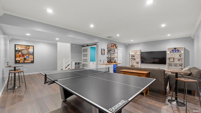 12946 Magnolia Creek Trl, Fort Wayne, IN 46814 - game room featuring a barn door, ornamental molding, wood finished floors, recessed lighting, and bar with sink