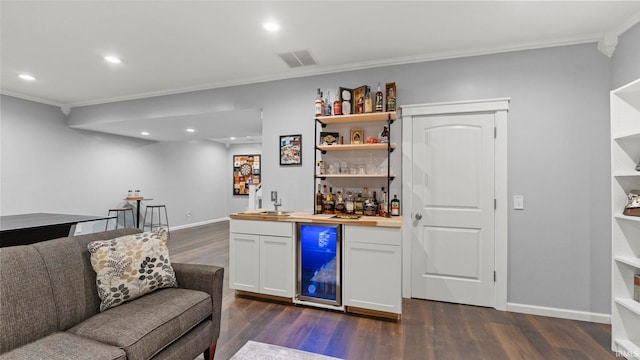 12946 Magnolia Creek Trl, Fort Wayne, IN 46814 - indoor wet bar featuring crown molding, wine cooler, dark wood finished floors, recessed lighting, and baseboards