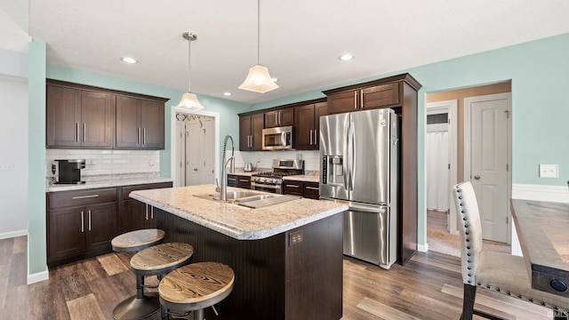 12946 Magnolia Creek Trl, Fort Wayne, IN 46814 - kitchen with appliances with stainless steel finishes, dark wood-style flooring, dark brown cabinets, light countertops, and recessed lighting