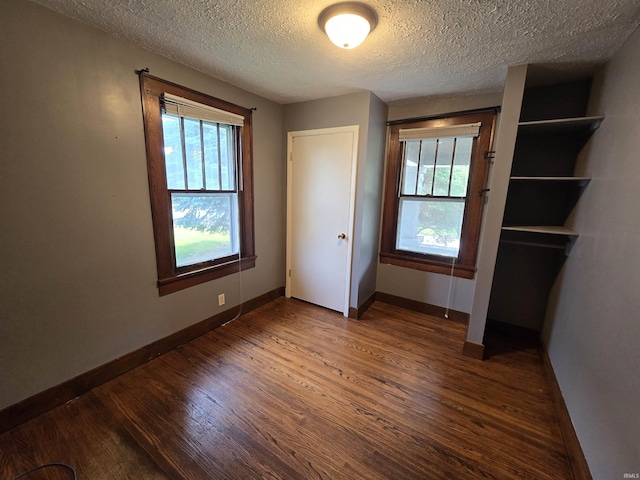 135 S 27th St, Lafayette, IN 47904 - unfurnished bedroom featuring wood finished floors, baseboards, multiple windows, and a textured ceiling