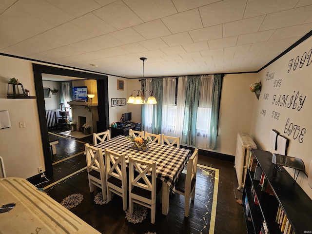 209 Seminary St, Vincennes, IN 47591 - dining area featuring radiator heating unit, a fireplace, and a chandelier