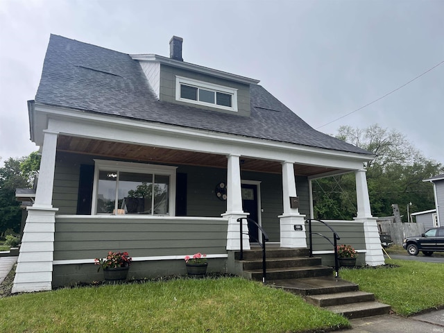 1302 Linden Ave, South Bend, IN 46628 - bungalow-style home featuring a porch, a front lawn, roof with shingles, and a chimney