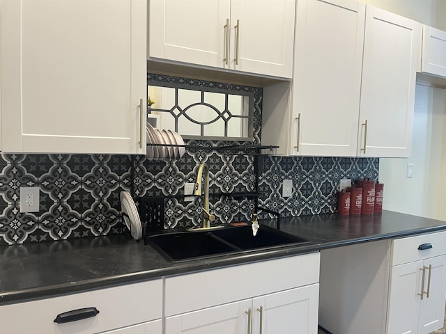 1302 Linden Ave, South Bend, IN 46628 - kitchen featuring a sink, dark countertops, white cabinets, and backsplash