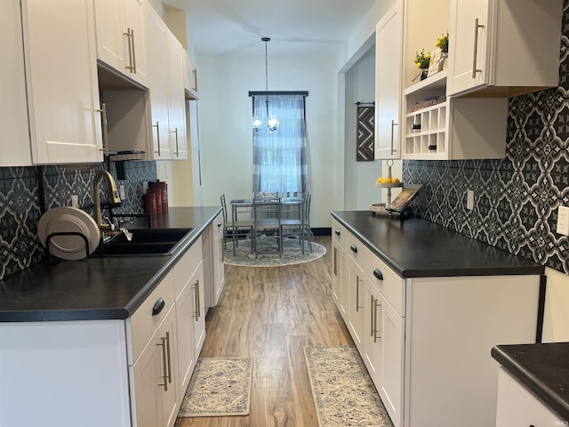 1302 Linden Ave, South Bend, IN 46628 - kitchen with a sink, dark countertops, light wood-style floors, a chandelier, and tasteful backsplash