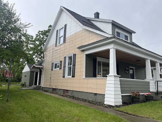 1302 Linden Ave, South Bend, IN 46628 - view of property exterior featuring a yard, covered porch, and a chimney
