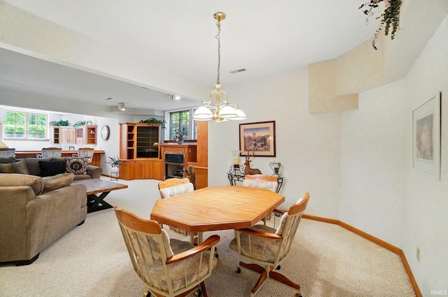 6011 W Wallen Rd, Fort Wayne, IN 46818 - dining room featuring light carpet, a chandelier, a fireplace, and baseboards