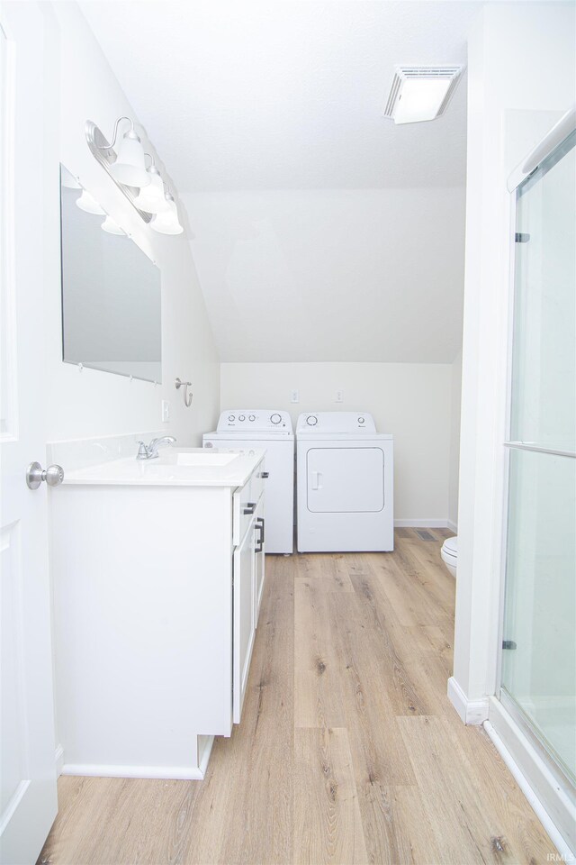 9031 Mill St, Stockwell, IN 47983 - bathroom with wood finished floors, vanity, separate washer and dryer, a stall shower, and vaulted ceiling