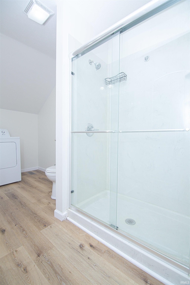 9031 Mill St, Stockwell, IN 47983 - full bathroom featuring washer / dryer, toilet, wood finished floors, lofted ceiling, and a stall shower