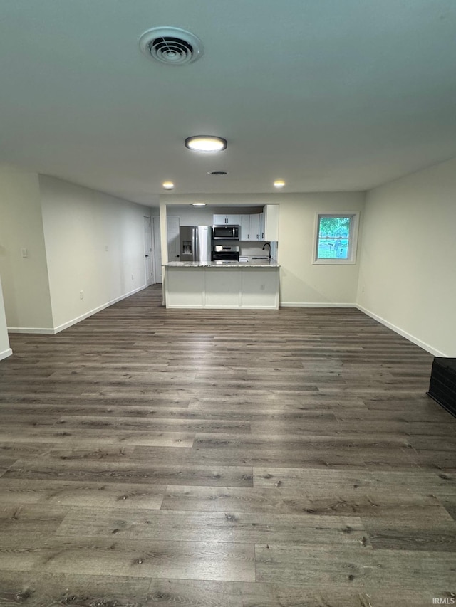 701 Ravine Park Blvd, Attica, IN 47918 - unfurnished living room with dark wood-style flooring, baseboards, and recessed lighting